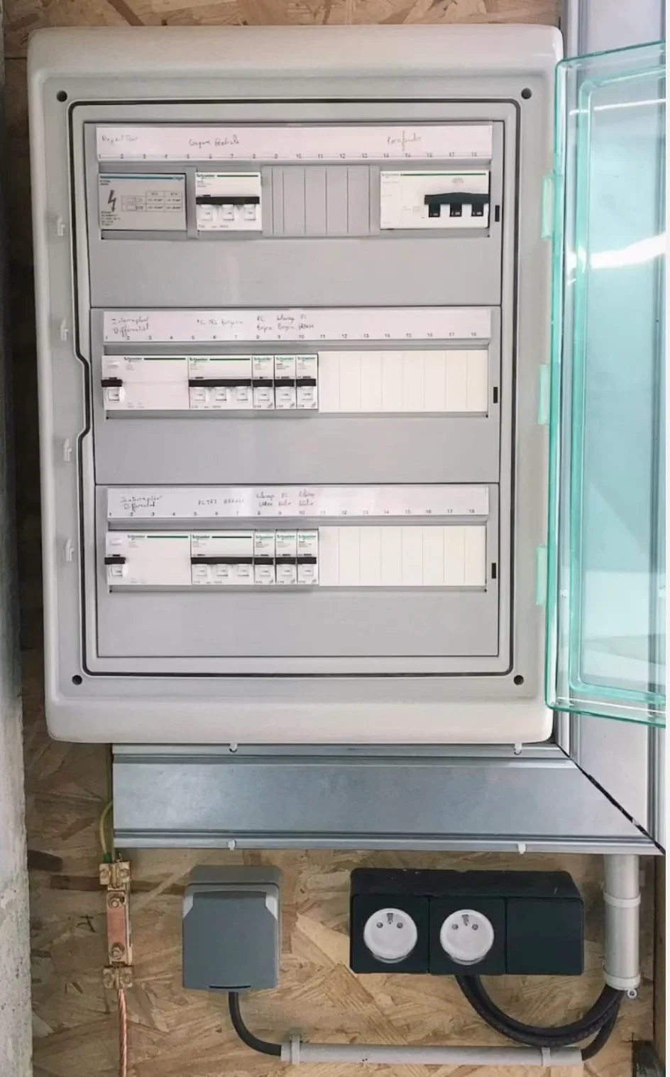 Tableau électrique installé par Jet’élec, porte transparente ouverte sur les protections et les circuits repérés